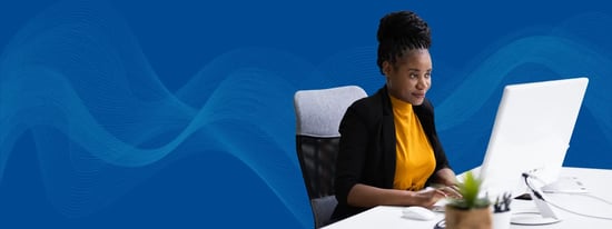 Woman using best check writing software at her desk with blue background 