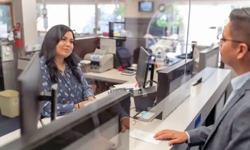 Bank teller helping out man at window copy