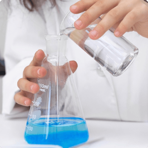 Blue chemicals being poured into a beaker copy