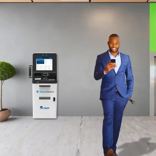Man in blue suit walking away from TellerCentral self-service machine 