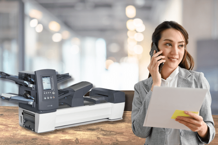 Woman on the phone in front of a Relay inserter machine