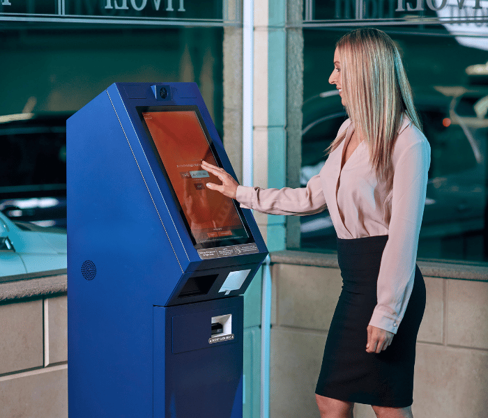 Woman using a next generation self service machine in a bank copy