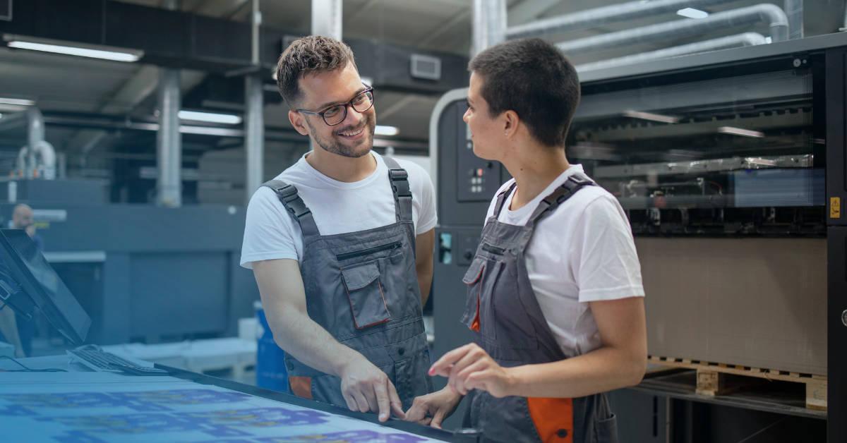 Print shop workers using a flatbed UV printer