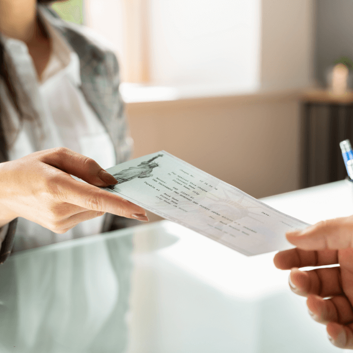 Teller handing customer a cashier's check