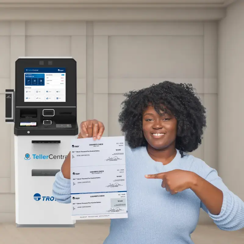 Woman holding cashier's check in front of TellerCentral self-service kiosk